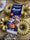 Nordic Ware Bundt pan set with a blue package in the center and several gold-colored fluted bundt pans arranged around it on a countertop.